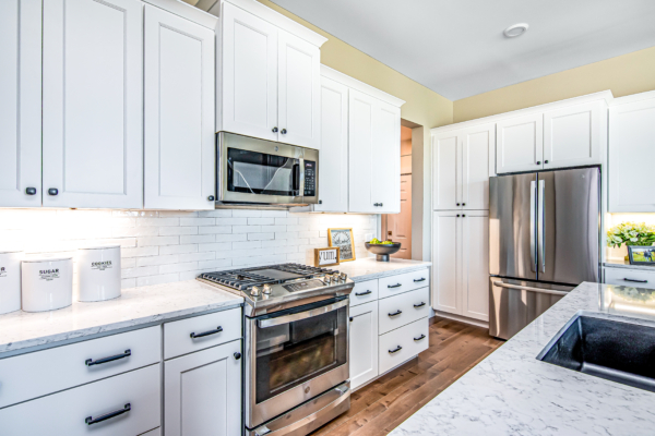 Modern kitchen interior with white cabinets, stainless steel appliances, and a subway tile backsplash.