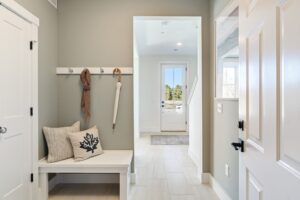 A hallway with a bench and a coat rack