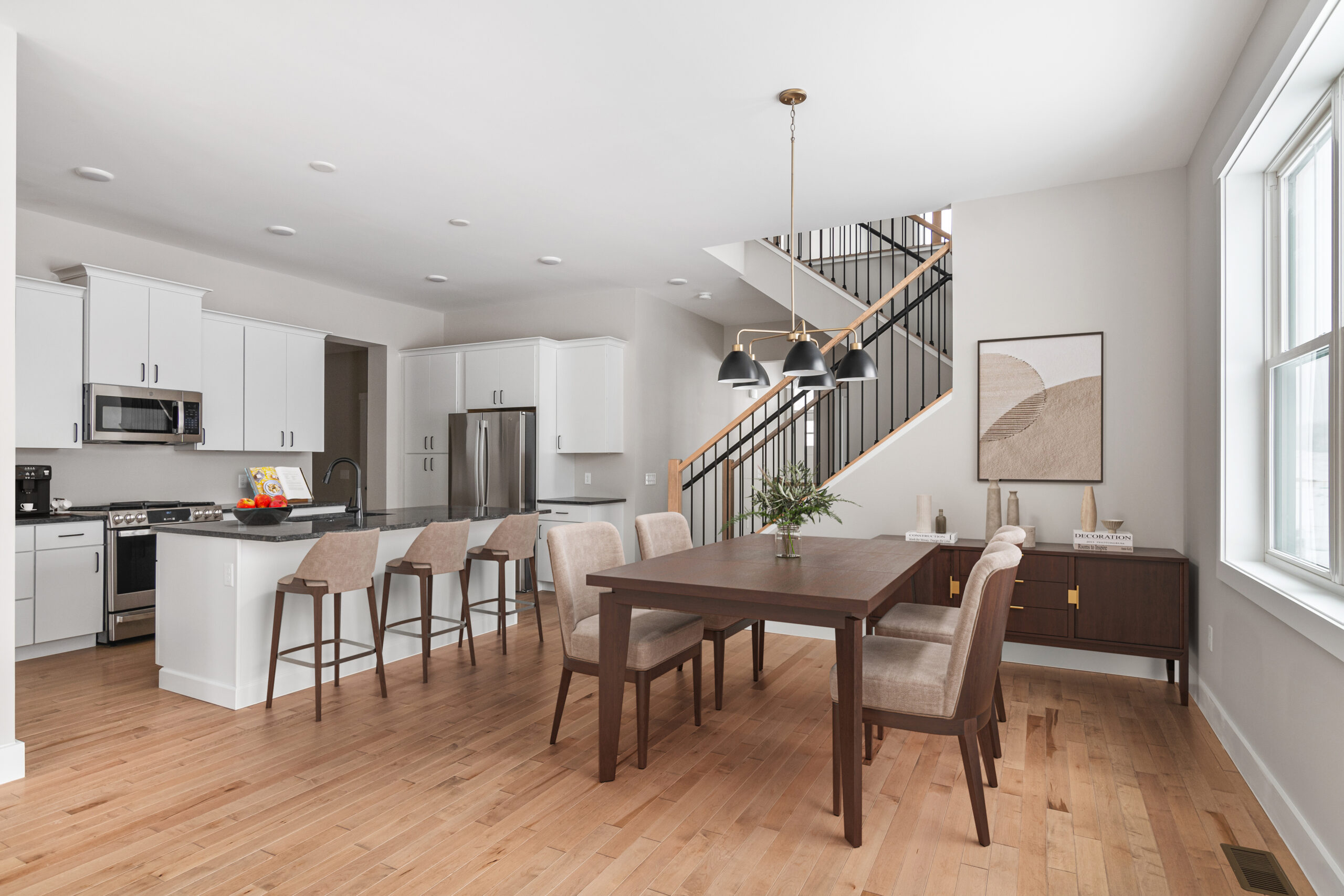 Modern kitchen and dining area at 68 Eden Lane with wood floors, white cabinets, and neutral-toned furniture.
