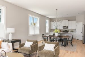 Open-concept living and dining at 71 Elm Street, featuring neutral tones, modern furniture, and a kitchen backdrop.