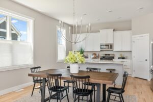 Bright kitchen and dining area at 71 Elm Street with a wooden table, black chairs, and a large white flower centerpiece.
