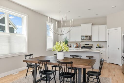 Bright kitchen and dining area at 71 Elm Street with a wooden table, black chairs, and a large white flower centerpiece.