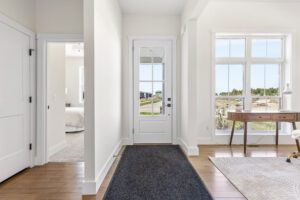 Bright entryway at 385 Beaudry Lane with a glass door, large windows, a desk, and outdoor views.