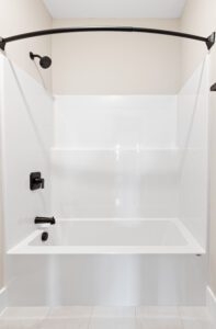 Modern bathroom at 68 Eden Lane features a white tub-shower combo, black fixtures, and a curved shower curtain rod.