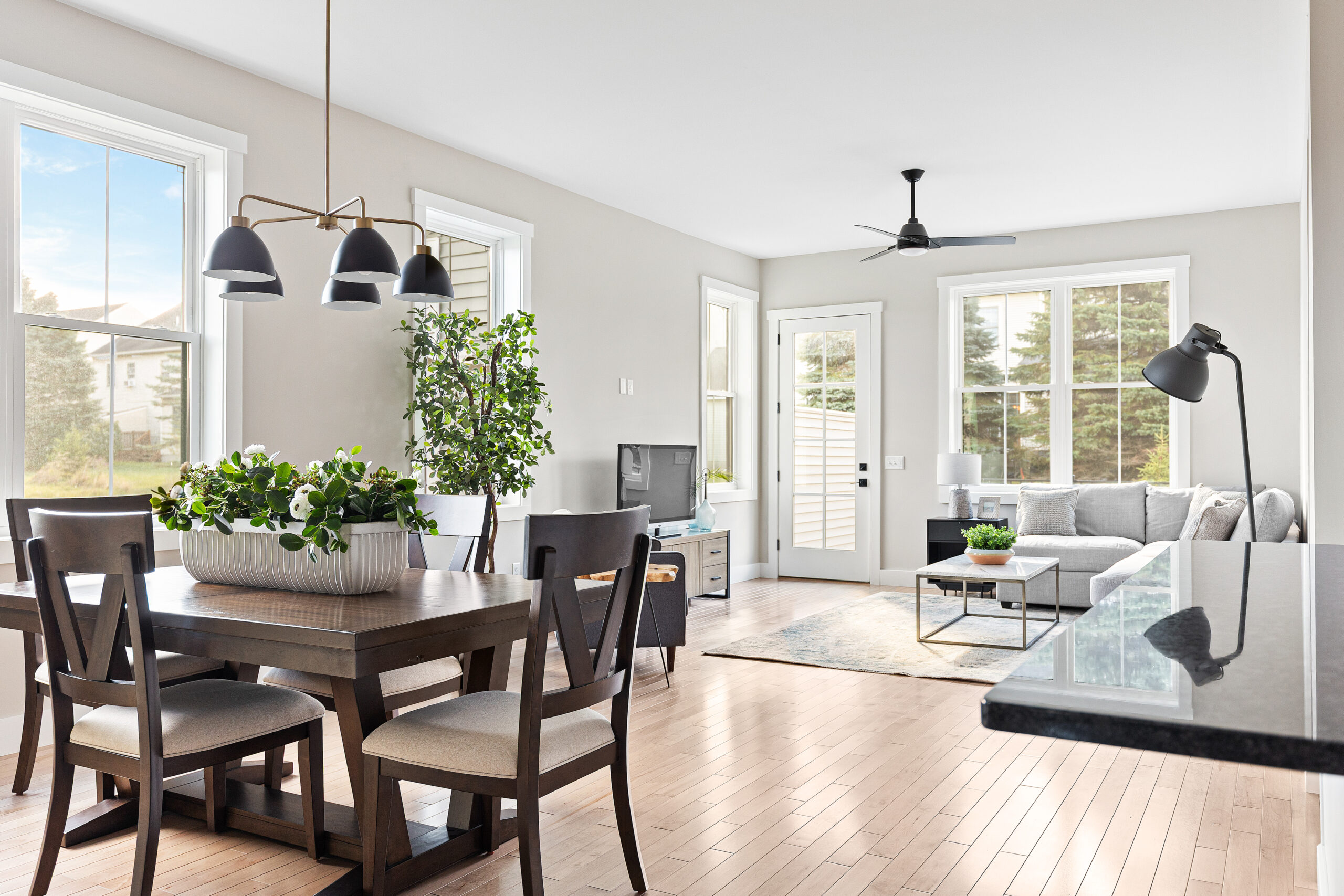 Modern, bright open-concept living and dining area at 68 Eden Lane with large windows, plants, and neutral furnishings.