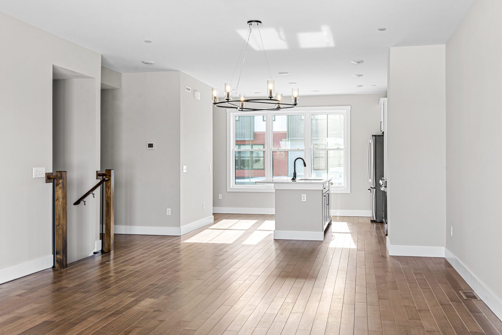 Bright, modern open-concept kitchen and living area at 188 Alpine Drive with wood floors, white walls, and large window.