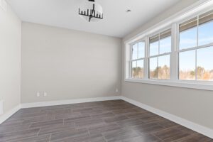 Bright empty room with large windows, tiled floor, and modern lighting at 188 Alpine Drive.