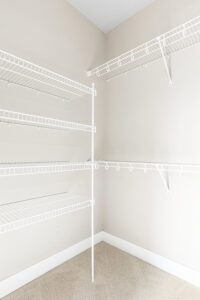 Empty walk-in closet at 188 Alpine Drive with white wire shelving, beige walls, and a carpeted floor.