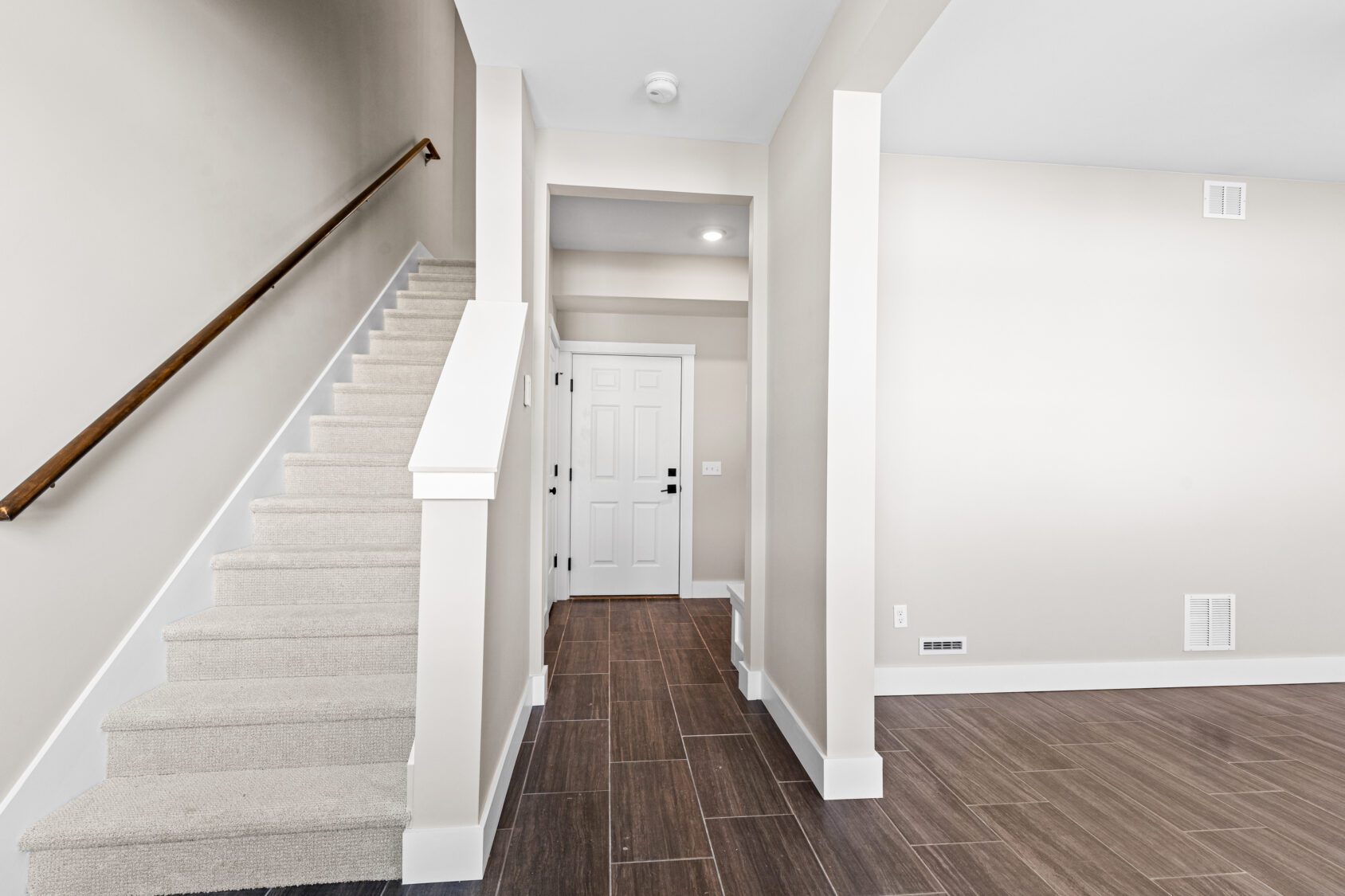 Modern entryway at 188 Alpine Drive with tiled floor, white walls, and a carpeted staircase to the upper level.
