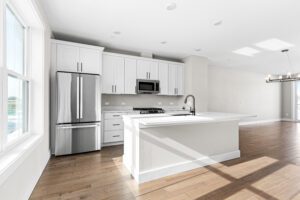 Modern kitchen at 188 Alpine Drive with white cabinets, stainless appliances, island, and natural light.