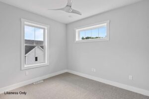 Empty, bright room at 136 Elm Street with two windows, neutral walls, beige carpet, and a modern ceiling fan.