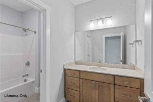 Modern bathroom at 136 Elm Street with a wooden vanity, large mirror, and bathtub with shower curtain rod.