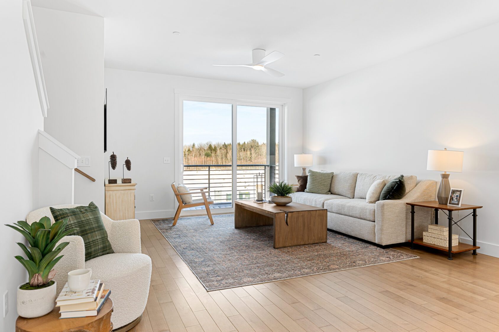 Bright, modern living room at 196 Alpine Drive with neutral furniture, a large rug, plants, and balcony access.