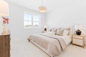 Bright, modern bedroom at 196 Alpine Drive with a neatly made bed, bedside tables, lamps, and a large window.