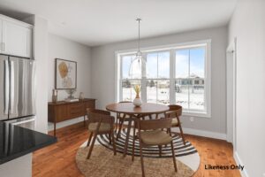 Modern dining area with wooden table and chairs, large windows, and snowy 196 Alpine Drive views outside.