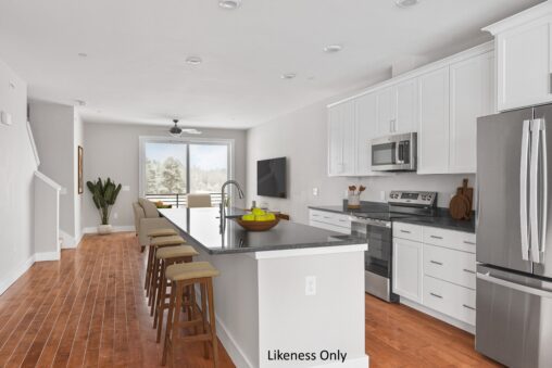 Modern kitchen on Alpine Drive with white cabinets, stainless steel appliances, island, and wooden stools.
