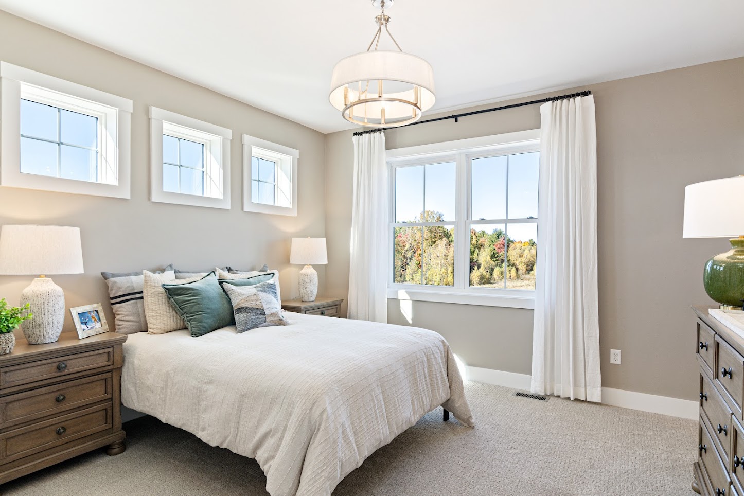 Bright bedroom at 162 Alpine Drive with a large bed, nightstands, dresser, and big windows with white curtains.