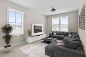Modern Paired Villa living room with gray sectional, white rug, TV, potted plants, and bright Castlerock windows.